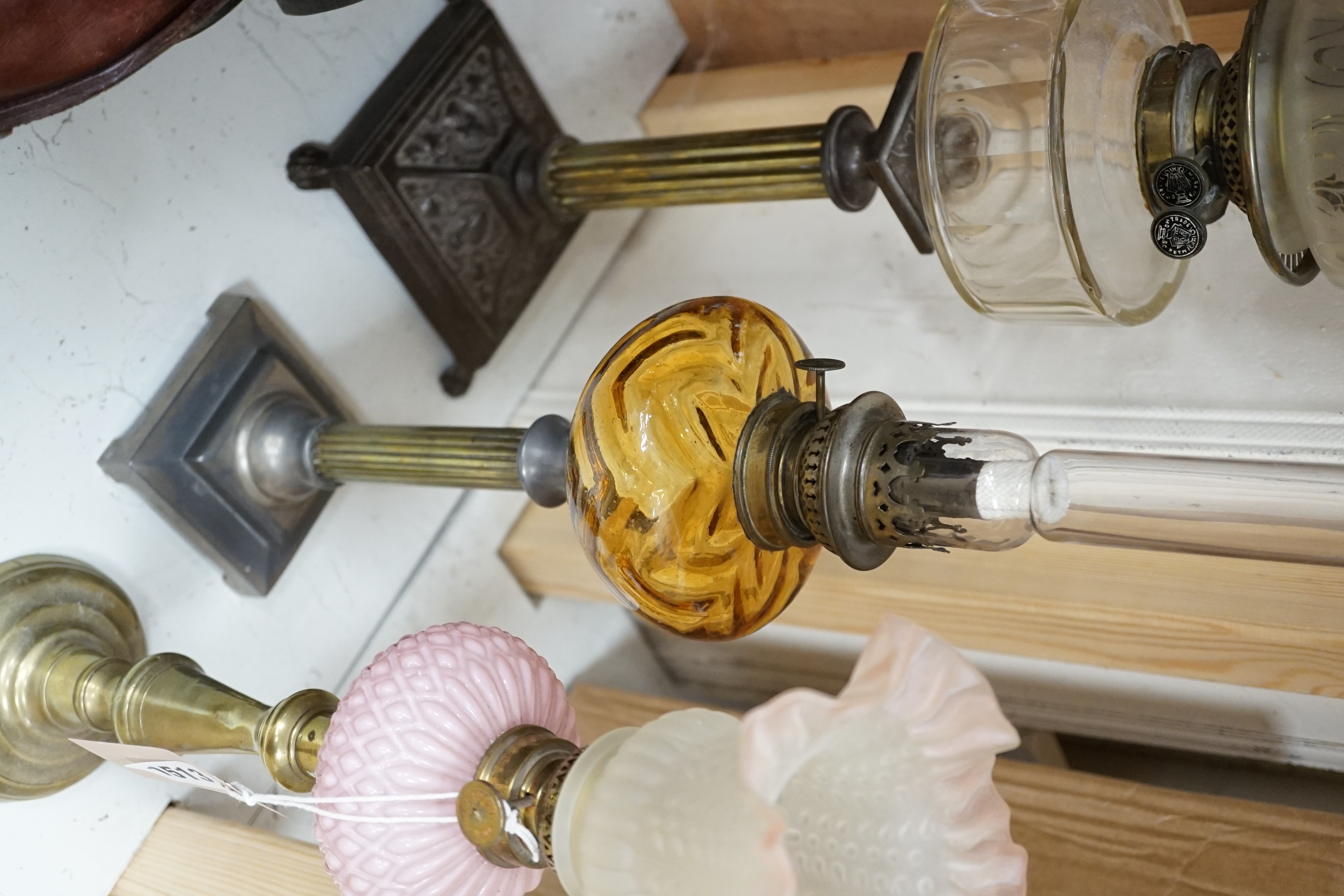 Three assorted glass and metal oil lamps, tallest 59cms excluding funnel